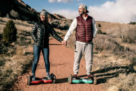 Woman and Man riding GOTRAX Red and Green SRX Pro All Terrain Hoverboards