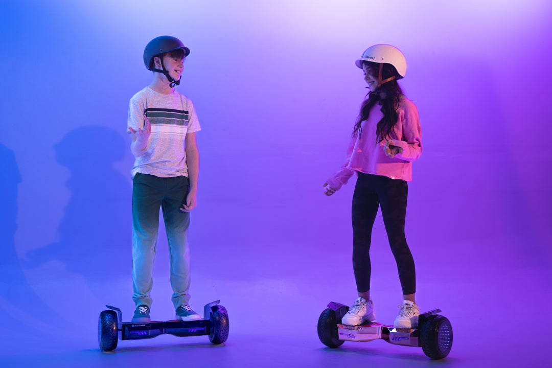 Children riding GOTRAX Black and Rose Gold E5 Off-Road Bluetooth Hoverboards with LED Infinity Wheels