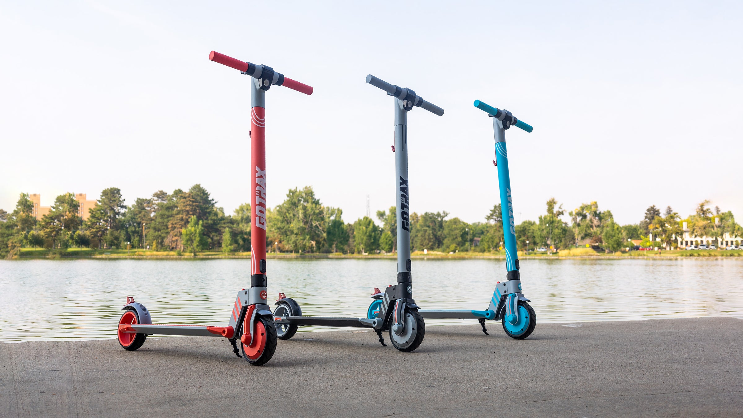 GOTRAX Red, Gray, and Teal Vibe Electric Scooter for Teens in a Park